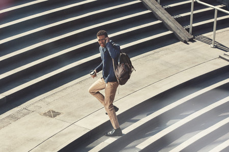 Businessman, walking and stairs with phone call for travel, communication or commute in city. Man,...