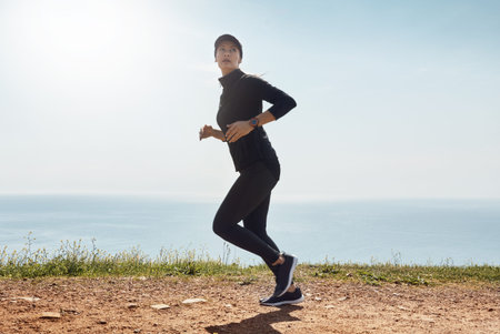 Fitness, woman and running by sea for cardio wellness, health and endurance training with space....