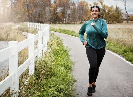 Running, woman and smile with workout, park and exercise routine with music for jog in nature....