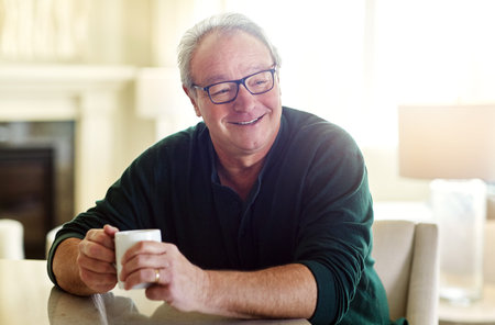Home, thinking and old man with coffee, laugh and relax with nostalgia, break and happy with memory....