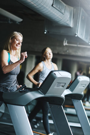 Runner, club and fitness with women on treadmill for speed challenge, workout and training. Gym...