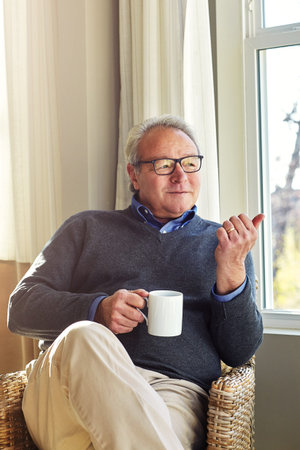 Cozy, reflection and relax with man on sofa in living room of home for ideas or weekend wellness....