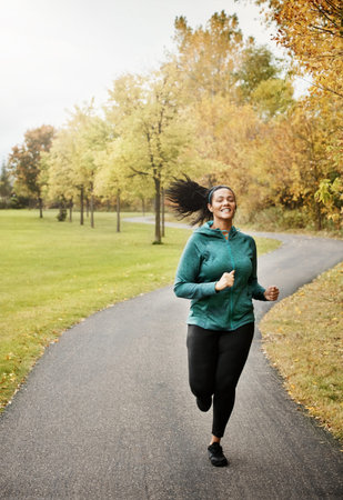 Active, woman and running in park with smile, endurance training or cardio challenge for wellness....