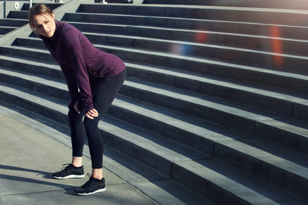 Woman, runner and tired in city for exercise on stairs, break or thinking with cardio in summer....