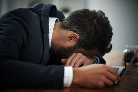 Exhausted, sleeping and businessman on laptop with deadline, report and bad time management in...