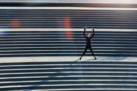 Woman, fitness or jumping jacks with stairs in city for workout preparation or outdoor exercise....