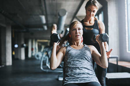 Fitness, personal trainer or woman with weights in gym, strength challenge or support for training....