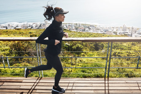 Workout, woman and running outdoor on bridge for cardio wellness, body health and endurance....