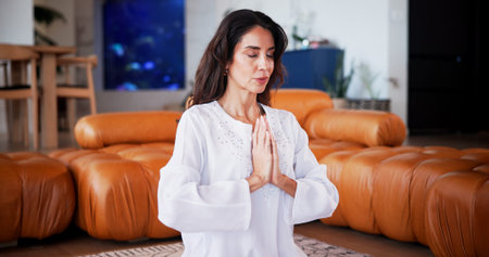 Meditation, prayer hands and woman in house for wellness, self care or health in living room. Yoga,...