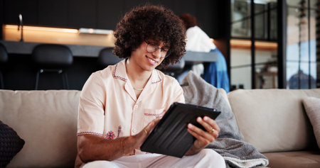 Happy, man and relax with tablet at house for social media, streaming movies and weekend break....