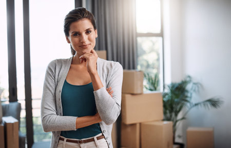 Portrait, moving and happy with woman in new home for interior designer, boxes and smile....