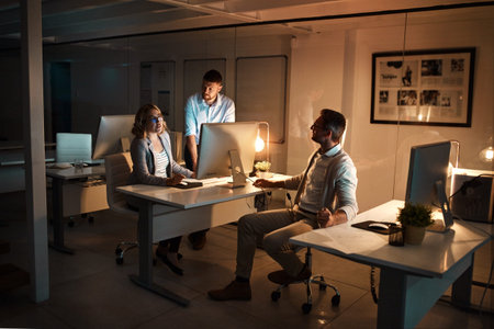 Computer, night and team with business people in office together for deadline or overtime....