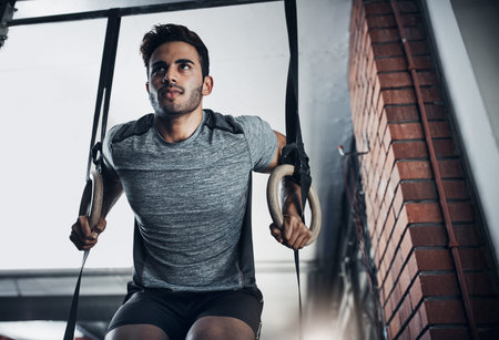Fitness, rings or man in gym with training, power pull up or bicep tone in bodybuilding. Exercise,...