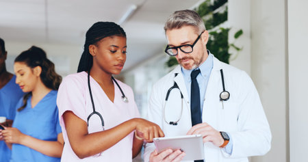 Hospital, meeting and doctor on tablet with nurse for online report, patient results and treatment plan. Healthcare, team and man and woman on tech for medical research, surgery schedule and adviceの写真素材