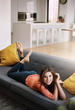Happy, relax and portrait with woman on sofa in home for comfortable, self care and weekend break....