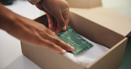 Person, hands and thank you card with box for logistics, courier service or packaging in small...
