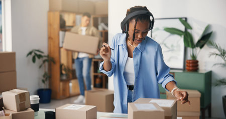 Boxes, headphones and woman in office, person, cardboard and entrepreneur in workplace, sound and...