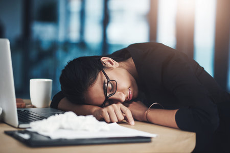 Tired, woman and sleeping at laptop in office for low energy, flu fatigue or overworked on deadline....