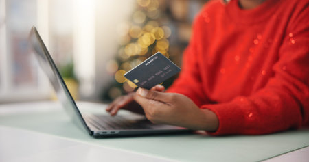 Person, hands and laptop with credit card for online shopping, payment and Christmas in home....