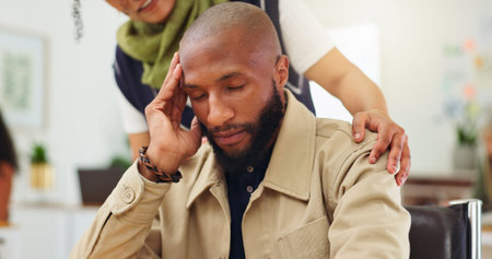 Man, headache and team with stress at startup, frustrated and support with fatigue at office. Person, migraine and computer with staff, helping hand and burnout with deadline at creative agencyの写真素材