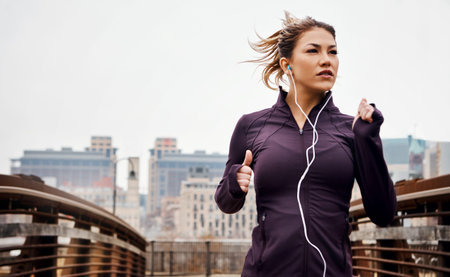 Exercise, girl and running with earphones in city for morning jog, wellness podcast and fitness...
