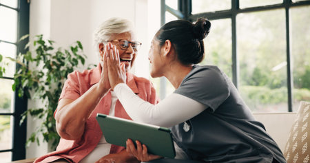High five, medical and tablet with nurse and old woman in home living room for success or support....