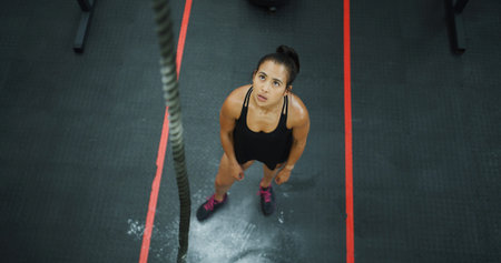 Above, thinking and woman with rope at gym for fitness, climbing exercise and weightlifting....
