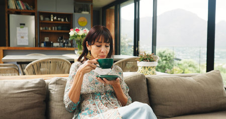 Woman, cup and sofa with tea for morning beverage, fresh start or comfort drink in home. Female...