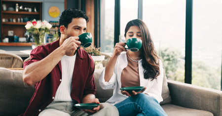 Couple, relax and people with coffee, lounge and chilling with hot drinks in home, break and...