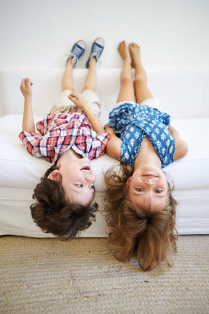Upside down, relax and kids on couch with fun, playing and happiness for weekend break and bonding....