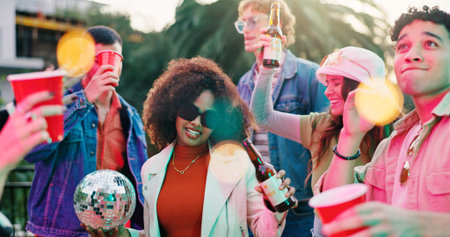 Alcohol, dance and party with friends outdoor together for bonding, celebration or social gathering. Drink, fun and reunion with group of people in backyard of home for energy, holiday or weekendの写真素材