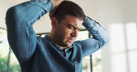 Frustrated, man and headache with stress in home for burnout, fatigue or financial mistake. Loss,...
