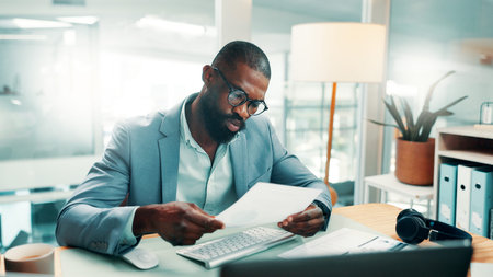 Black man, documents and report with computer at office with glasses, review or perspective at...