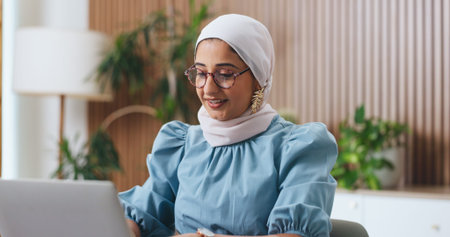 Muslim woman, laptop and typing with smile in office for admin, glasses or insight at insurance...