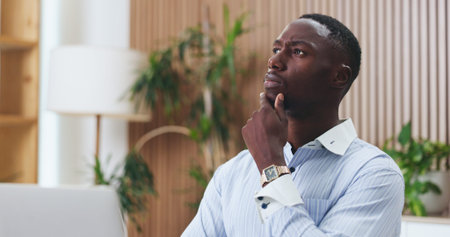 Office, employee and black man with laptop, thinking or risk management with financial report on...