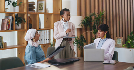 Woman, tablet and documents with team in office meeting for strategy, laptop and insight at...
