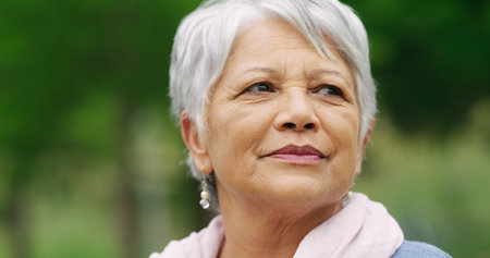 Elderly woman, reflection and relax in park with travel, memory or nostalgia. Senior person,...