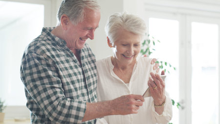 Mobile, senior and couple in home with happiness, reading good news or funny joke in retirement....
