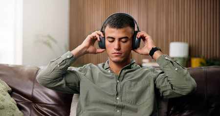 Man, headphones and reflection on sofa with streaming, chill audio and break on weekend in home....