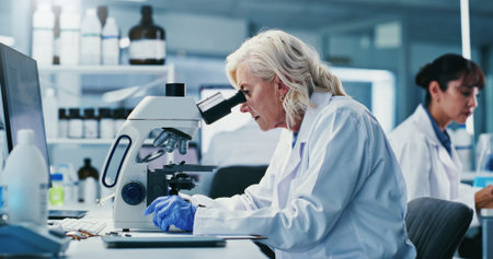 Woman, scientist and microscope with study at lab for notes, medical research and gloves for virus...