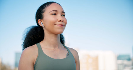 Runner, thinking and woman with earphones in city on break for exercise, workout and training....