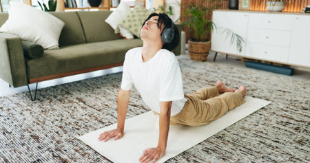 Music, stretching and yoga with Asian man in home living room for exercise or wellness routine....