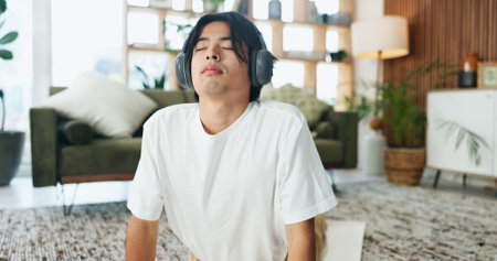 Headphones, stretching and yoga with man on floor in home living room for exercise or wellness...