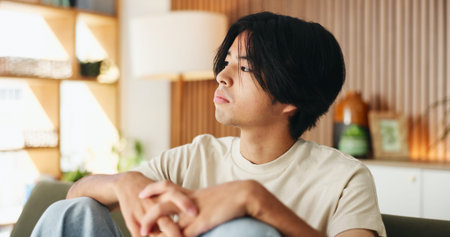 Thinking, sad and man on sofa in house with regret for decision or choice with mental health....