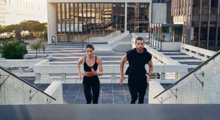 Healthy, couple or athletes in city running on stairs for exercise, workout or training for...