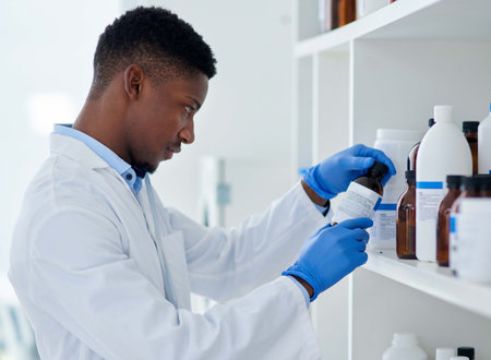 Scientist, chemical and black man with bottle in lab for medical research, information and...