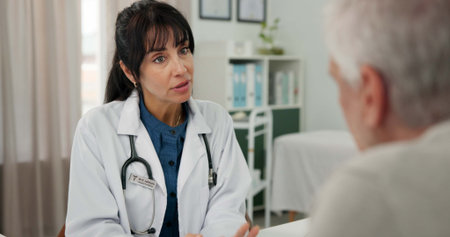 Doctor, woman and talking to old man in clinic for health advice, treatment progress or planning. Hospital, senior patient and mature professional with feedback for healthcare, results and diagnosisの写真素材