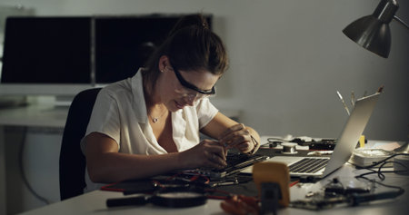 Woman, technician and repair with laptop in workshop for IT service, maintenance or engineering....