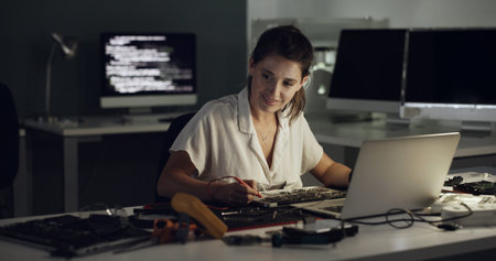 Night, laptop and woman with hardware for IT maintenance, repair and diagnostics for software. Technology, technician and female engineer with tools for troubleshooting, system test or programmingの写真素材
