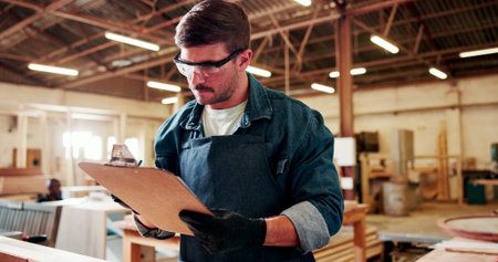 Carpenter, man and inspection in workshop with clipboard, review manufacturing and building project....